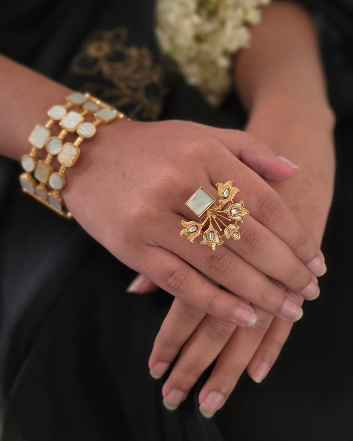 Muskan cuff and a statement ring, worn