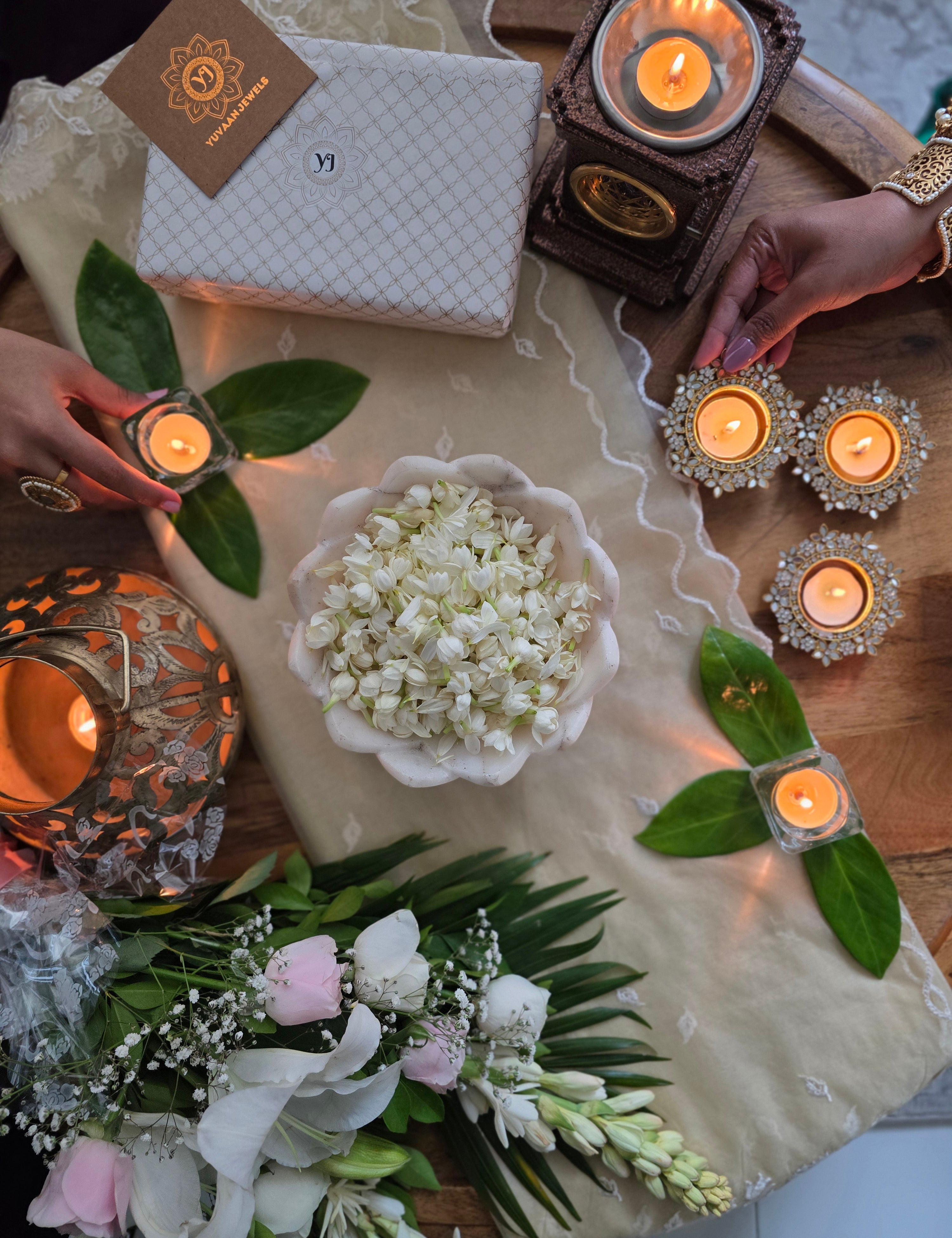 A Yuvaan gift box with diyas and flowers