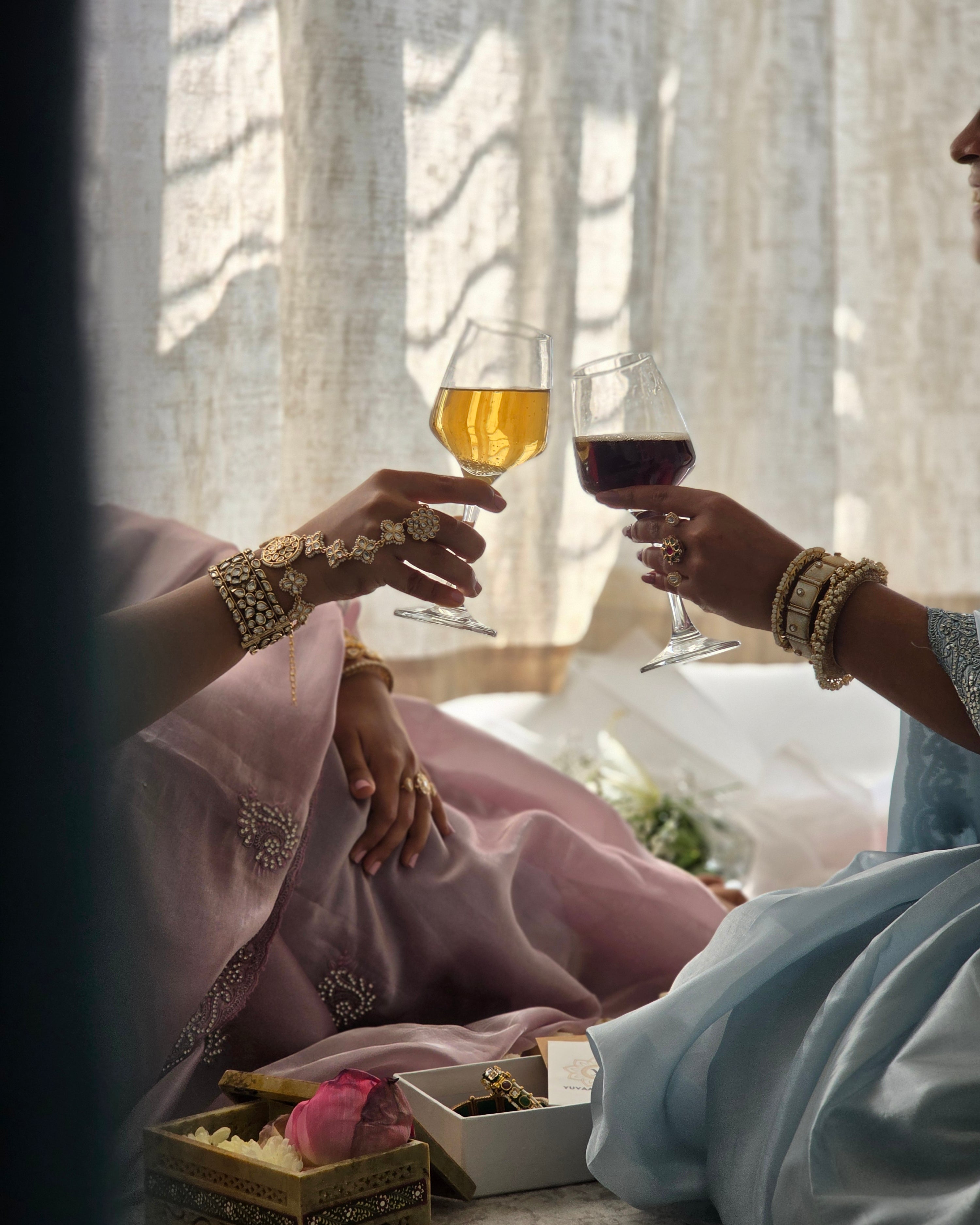 Two women in pastel sarees with bangles